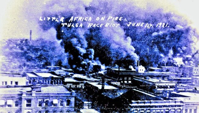 A photograph captures the physical destruction of the 1921 Tulsa Massacre ;"Tulsa Race Riots June 1921" by over 26 MILLION views Thanks is licensed with CC BY-NC-SA 2.0. To view a copy of this license, visit https://creativecommons.org/licenses/by-nc-sa/2.0/