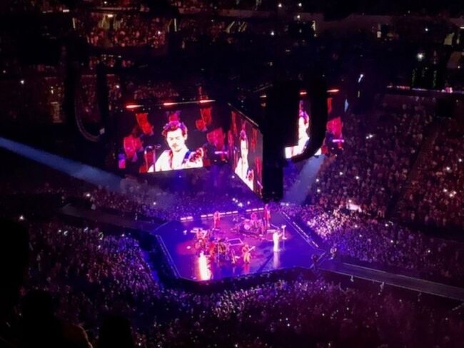A jumbotron of Harry Styles above the audience in the American Airlines Stadium.