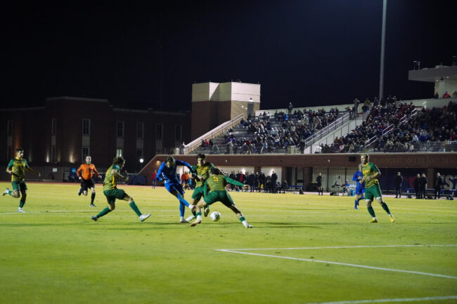 Forward Bailey Sparks scores SMU's second goal, surrounded by Vermont defenders.