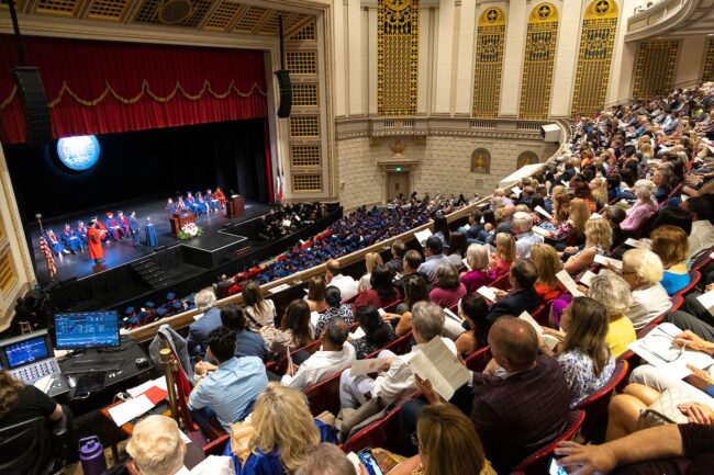A crowd of graduates and their supporters gaze upon commencement speakers in McFarlin Auditorium. Image courtesy SMU.
