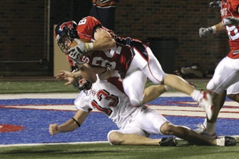 SMUs Zach Sledge (No. 84) rolls over Arkansas States Brett Shrable (No. 13) after recovering a mishandled punt for a touchdown during Saturday nights 55-9 victory over the Indians at Ford Stadium.
