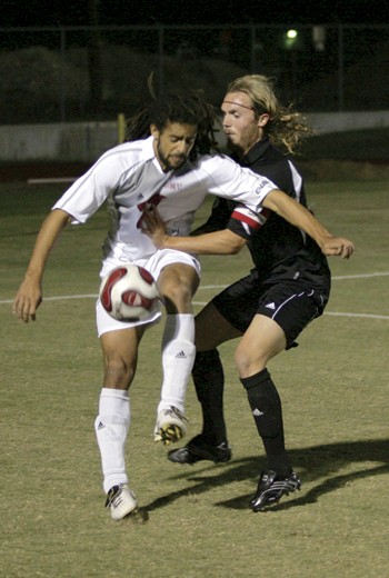 SMUs Adrian Chevannes (left) fights for the ball against South Carolinas Ryan Leeton (right).