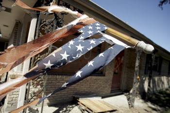A tattered American flag hangs outside a ruined home at 5800 Pratt Dr. in New Orleans.  The street remains mostly abandoned more than a year after Hurricane Katrina.
