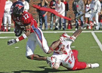 SMUs Emmanuel Sanders (left) gets tripped by Houstons Brandon Brinkley (right) during Saturdays game.  Despite the record breaking efforts of Sanders, the Mustangs were unable to come away with a win.