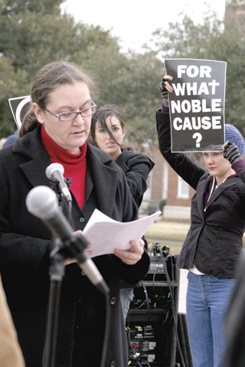 As the names of soldiers killed in the conflict in the Middle East were read Wednesday, students held up protest signs against the war.