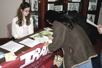 SMU student Tiana Lightfoot (left) looks on as UTD student Sakina Hussain signs a petition to help the human rights movement. 