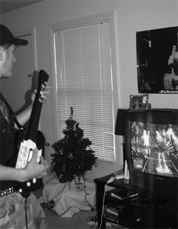 Jared Caraway, striking his best rockstar power stance, plays a hardcore round of Guitar Hero.
