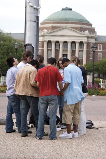 A group of SMU students hold an impromptu prayer circle at the Flagpole on Monday in response to the shootings at Virginia Tech.