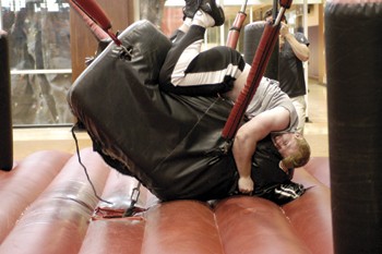 Student Cory Payne rides the bull at Mane Event 2007. It was moved inside the Dedman Center due to stormy weather.