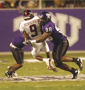 SMUs Jessie Henderson (center) is taken down by TCUs Jerry Hughes (right) during Saturday nights game in Fort Worth.