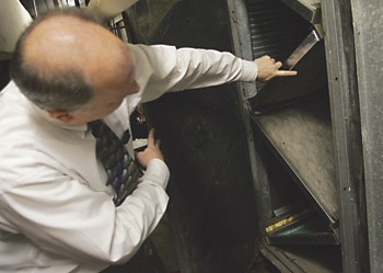 Mike Paul, director of energy management for Campus Planning and Plant Operations points out the new filters that were installed in the air unit in Moore Hall.