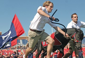 Peruna Handlers Stuart Campbell (left) and Bryan Shnider run with Peruna before the start of the SMU vs. UTEP game.