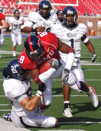 SMUs DeMyron Martin is tackled by a Rice defensive player as Rice cornerback Gary Anderson Jr. looks on.