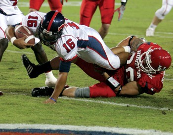 SMU quarterback Justin Willis (16) dives into the end zone for a touchdown past Houstons Rocky Schwartz (20) during the first quarter of Sunday nights game.