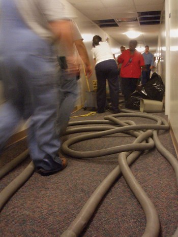 Workers crowd a hallway in Moore Hall while trying to clean up water from a burst pipe.