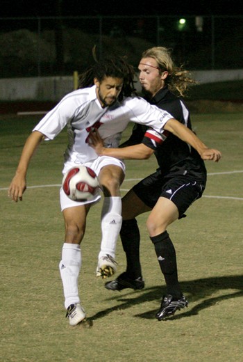 The Mustangs Adrian Chevannes battles to clear the ball.