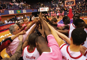 The SMU mens basketball team huddles at center court after beating Rice.