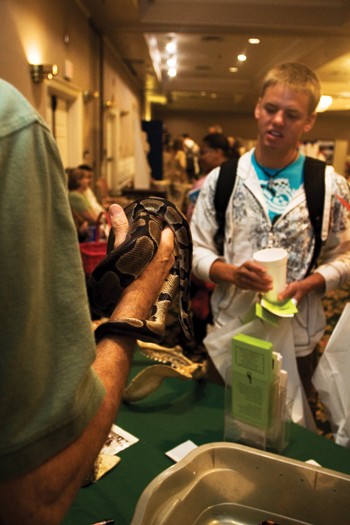 Sophomore Ross Neubauer and look on as a representative from the Dallas Zoo handles a snake at the Volunteer Expo yesterday in Hughes-Trigg.