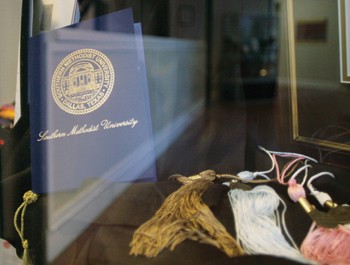 Sample graduation materials rest in a display case in Hughes-Trigg.