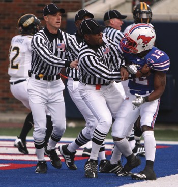 SMUs Derrius Bell attempts to free himself from an officials grasp Saturday night at Ford Stadium after a scuffle with Southern Mississippis DeAndre Brown. Both players were ejected from the game.