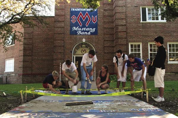 Freshman members of the Mustang Band partake in the annual homecoming tradition of painting the concrete leading to the band hall in spirited red and blue colors. MICHAEL DANSER/The Daily Campus