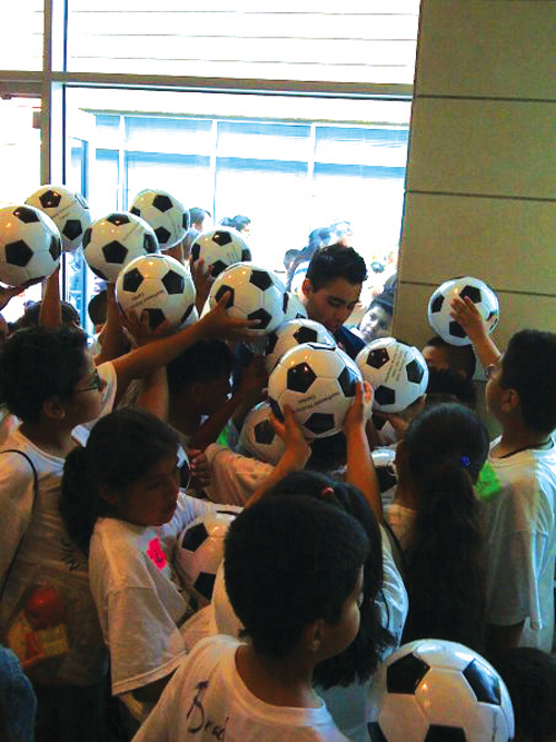 SMU junior Brad Namdar signs soccer balls to promote Dream Big Soccer Camp.