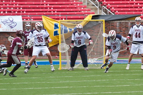 Long Stick middle player Taylor Harbison of the SMU Lacrosse team scoops up a stolen ball against Texas A&M Saturday during the Patriot Cup at Ford Stadium.