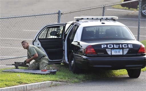 A Police officer sets up nearby the Hartford Distributors, Inc., in Manchester, Conn., Tuesday, Aug. 3, 2010. Authorities say several people have been killed at the beer distribution company in Connecticut. 