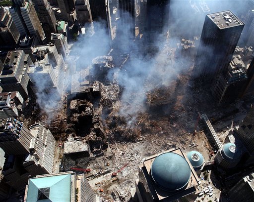 In this Sept. 17, 2001 file photo, the ruins of the World Trade Center continue to smolder almost a week after the Sept. 11 terrorist attack. Surrounding buildings were heavily damaged by the debris and massive force of the falling twin towers. While some feel that Ground Zero is the real estate that the World Trade Center occupied before falling in the 2001 terrorist attacks, others recognize an area that extends beyond the fence and into its lower Manhattan neighborhood