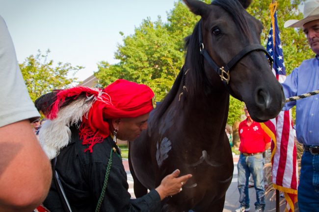 Travis Jackson Jr., a member of Seminole Nation, blesses Liberty, one of two donated mustangs by Madeleine Pickens.