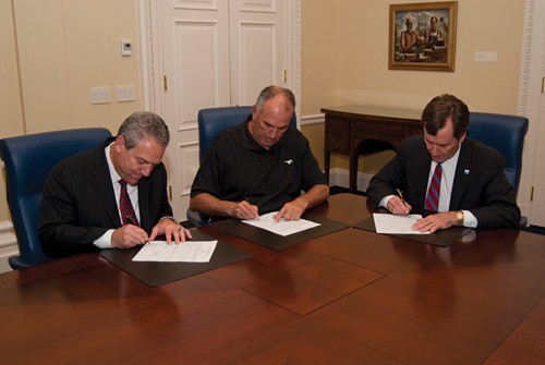 Athletic Director Steve Orsini, Head Coach June Jones and President R. Gerald Turner sign two-year contract extension.