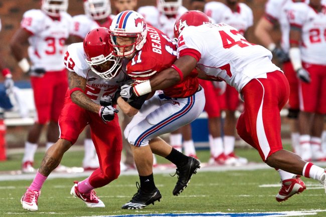 Houston defensive back Loyce Means, left, and linebacker Phillip Steward tackle SMU receiver Cole Beasley during play Saturday afternoon at Ford Stadium.