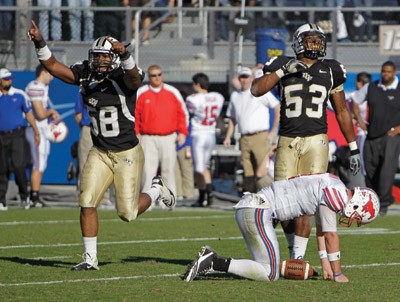 UCF defensive linemen Troy Davis, left, and Darius Nall celebrate after stopping SMU quarterback Kyle Padron on a fourth down play with only seconds left in the Conference USA championship game in Orlando, Fla., Saturday afternoon. UCF won the game 17-7.