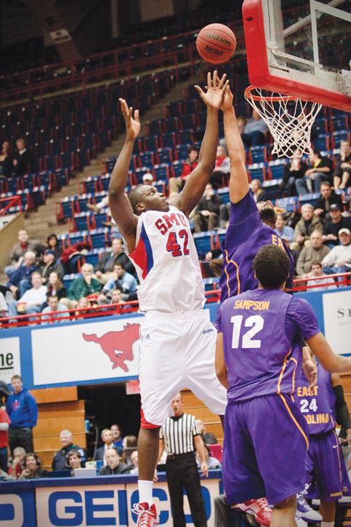 SMU forward Papa Dia goes for an offensive rebound against an East Carolina player Wednesday evening at Moody Coliseum. SMU managed a come from behind win to move into 3rd place in Conference USA.