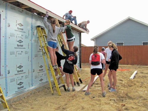 SMU students from Chi Omega help build a house as part of a Habitat for Humanity service initiative on Saturday.			       