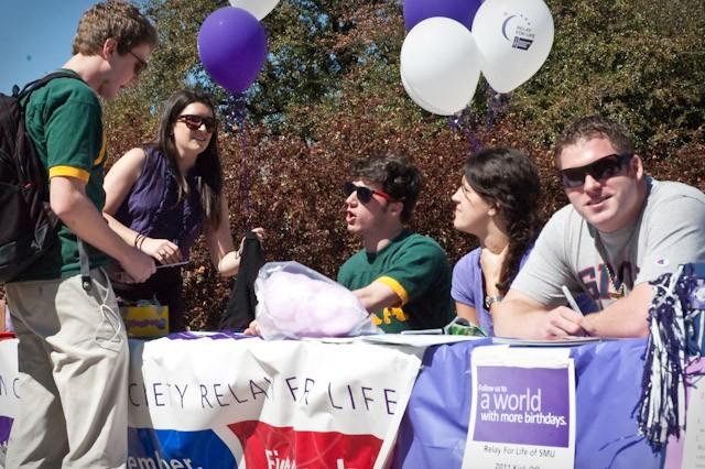 NASCAR driver Rob Richardson, right, sits at the Relay for Life booth by the flagpole Tuesday as SMU student Bretton Leafing, left, gathers information on the annual event from students Greg Pasiadis and Erica Gliga.