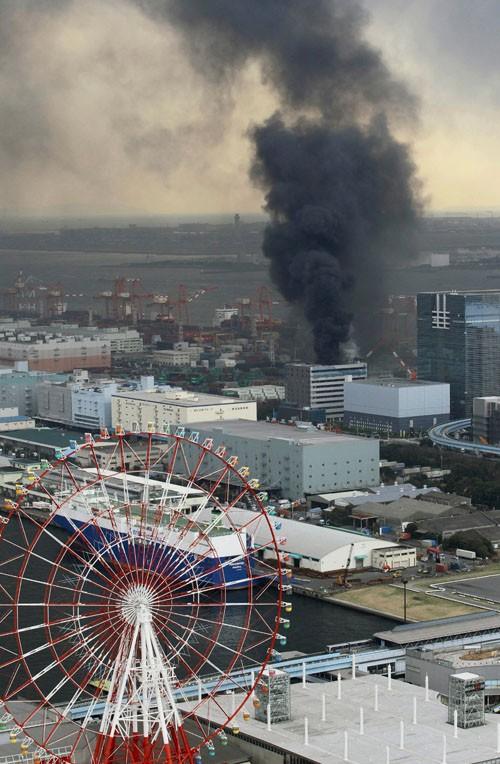 Black smoke rises from a burning building in Tokyo after Japan was struck by a magnitude 8.9 earthquake off its northeastern coast Friday, March 11, 2011.