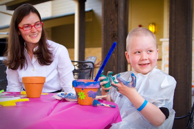 SMU graduate student Meredith Minister participates in decorating clay pots with six-year-old Leukemia patient Thomas Thompson during crafting time at the Ronald McDonald House in Dallas Thursday evening.