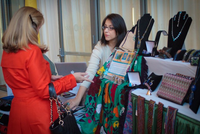 Alina Atash, of the company Artizan Sarai, shows products for sale Thursday morning inside the Collins Executive Center.