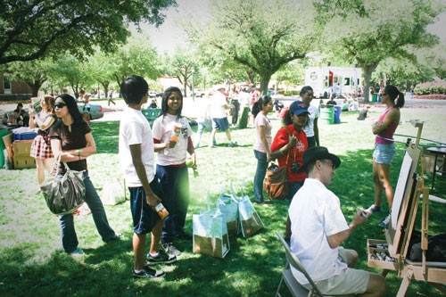 SMU students congregate around a cartoonist during Barefoot on the Boulevard Saturday afternoon.