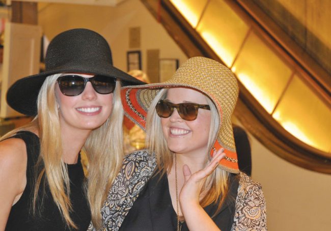 Neiman Marcus downtown duyer Alison Gross tries on hats with a friend in the store’s flagship location. 