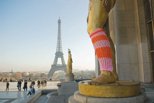 Guerilla knitters from the group Knitta Please hit a Parisian statue with a yarn bomb. 