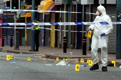 A forensic officer works at the scene where where three men were killed after being hit by a car in an incident locals some were linking to the violence early Wednesday Aug. 10, 2011 in Birmingham, England. The presence of thousands of extra police officers helped keep a nervous London quiet early Wednesday after three nights of rioting, but violence and looting flared in English cities including Manchester and Birmingham. 
