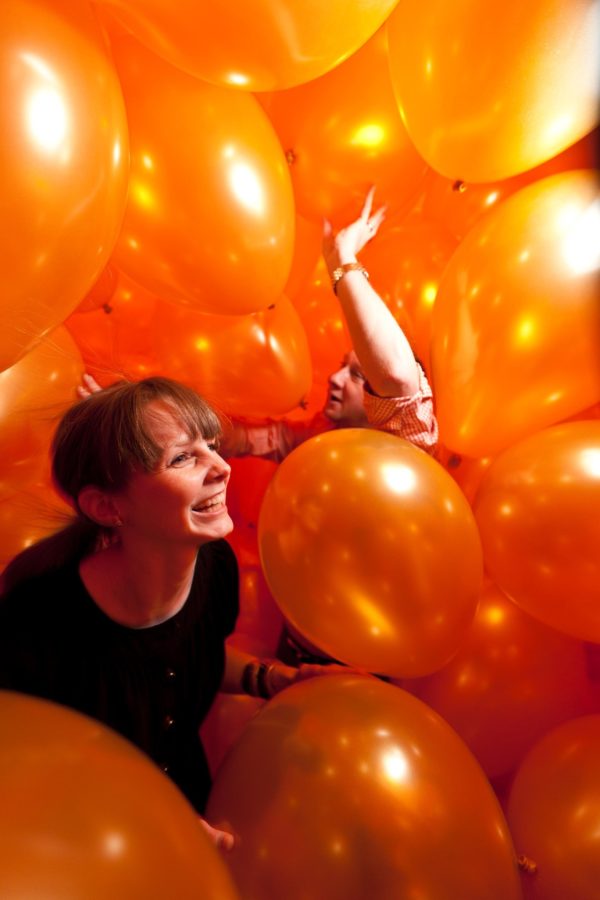 Two attendees throw balloons at one another inside Martin Creed's 
