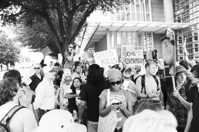 An Occupy Dallas organizer addresses the crowd after it marched to the Federal Reserve building. 