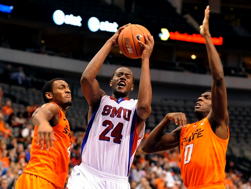 SMU forward Robert Nyakundi (24) drives to the basket between Oklahoma State guard Brian Williams (4) and forward Jean-Paul Olukemi (0)in the second half of an NCAA college basketball game in Dallas, Wednesday.