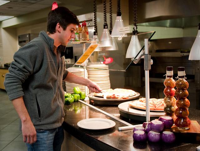 Freshman J.D. Mahaffey reaches for a slice of pizza at Umphrey Lee dining room.