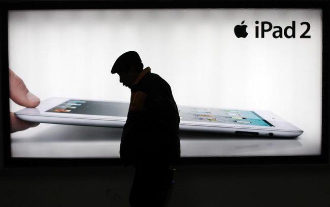 In this Feb. 28, 2012 file photo, a man walks past an advertisement of Apple’s iPad 2 in Shanghai, China. Chinese media reports said Monday, March 5, 2012, a major creditor of Proview Electronics, which is challenging Apple Inc.’s use of the iPad trademark, has moved to have the ailing computer monitor maker liquidated. Reports by the Xinhua News Agency and other mainland media said Taiwan-based Fubon Insurance is seeking $8.68 million in debts. 
