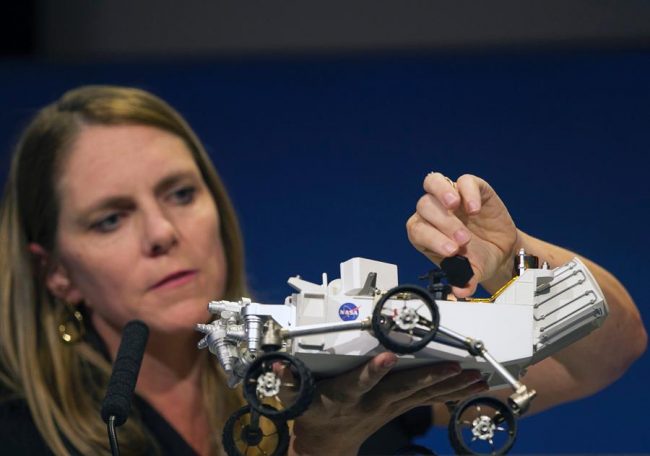 A+NASA+scientist+presents+a+model+of+Curiosity+to+a+room+of+reporters+days+before+Curiosity+reached+Mars.