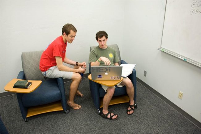 Williamson Slack and Alex Ussery, honors students, study on a whiteboard in the Scholars Den. 
